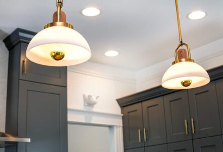 Hanging kitchen lights with white glass shades.
