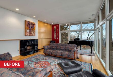 Couches and a chair with a foot stool surrounding a living room fireplace.