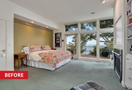 King-sized bed in a master suite with large windows.