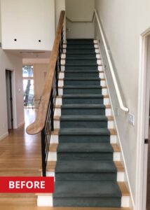Wooden staircase with dark carpet on top.