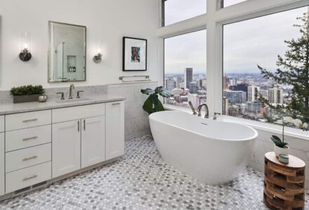 Soaking tub in front of four large bathroom windows.