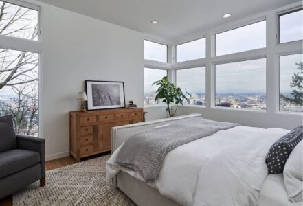 Master bedroom with a king bed opposite a wooden dresser.