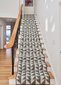 Wooden staircase with geometric-patterned Stark Carpet on the stairs.