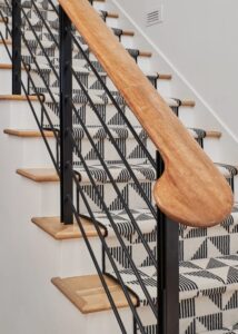Wooden staircase with geometric-patterned Stark Carpet on the stairs.