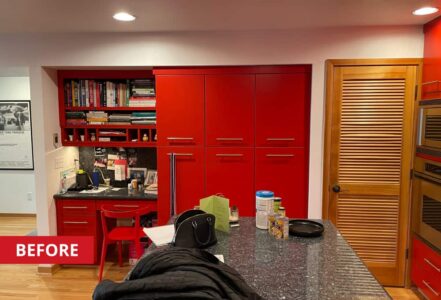 Kitchen with dark granite countertops and red paneled cabinetry.