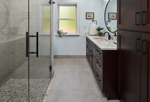 Bathroom counter from Architectural Surfaces with Moen Doux matte black bathroom sink faucet and hand towel holder.