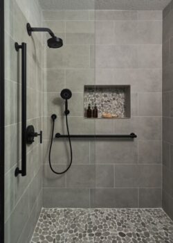 Bathroom counter from Architectural Surfaces with Moen Doux matte black bathroom sink faucet and hand towel holder.