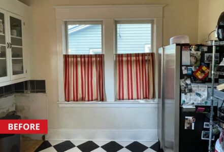 Two kitchen windows with red blinds.