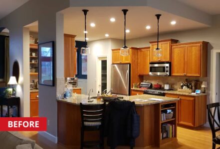 Kitchen space with a curve island, and oak-finished cabinets.