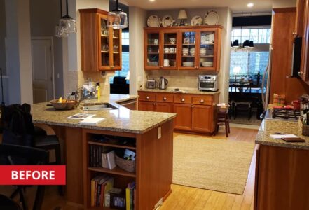 Kitchen space with a curve island, and oak-finished cabinets.