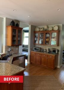 Kitchen space with a curve island, and oak-finished cabinets.