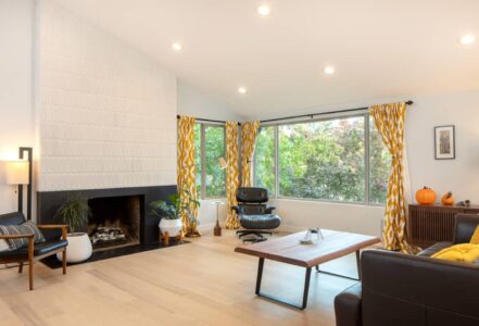 Living room space with a reshaped and reclad fireplace with mid-century-inspired Heath Ceramics tile.