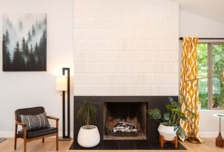 Living room space with a reshaped and reclad fireplace with mid-century-inspired Heath Ceramics tile.