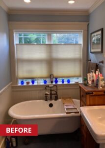 Clawfoot tub underneath a bathroom window.