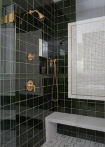 Shower with green bathroom wall tile and a shower bench.