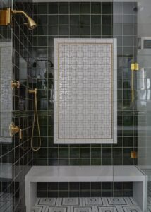 Shower with green bathroom wall tile and a shower bench.