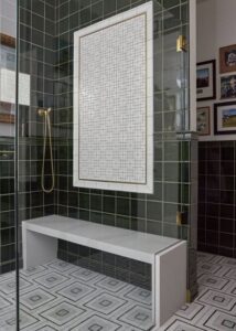 Shower with green bathroom wall tile and a shower bench.