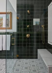 Shower with green bathroom wall tile and a shower bench.