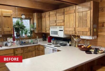 U-shaped kitchen in a cozy cabin with wooden cabinetry.