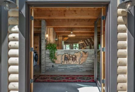 Bright entryway into an A-frame home with a stallion art piece.