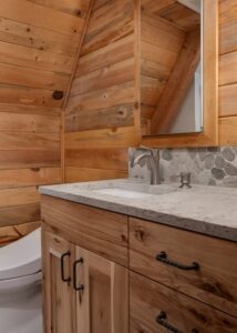 Bathroom vanity with grey granite countertop and a silver faucet.
