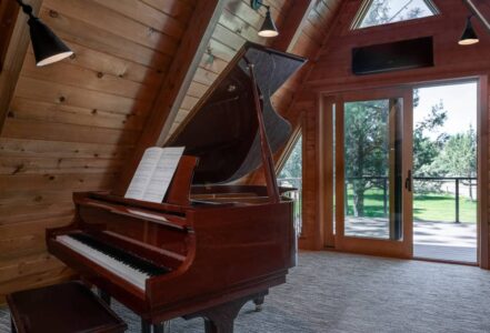 Grand piano at the entrance of a back patio in a home.