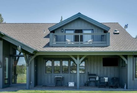Back patio of a Bend home with a grill and seating.