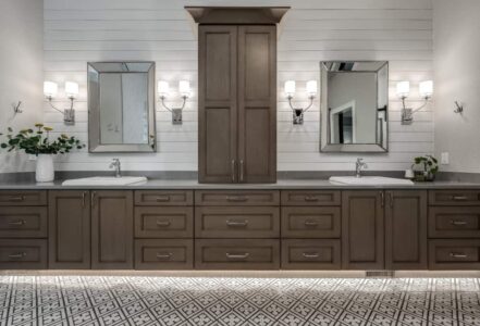 Double sink vanity along the wall of a primary bath with Decor cabinets.