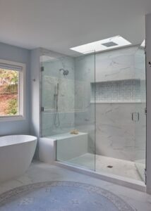 Signature Hardware oval acrylic freestanding tub to the left of a walk-in shower.