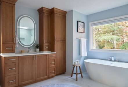 Natural wood dressing table in a primary bathroom.