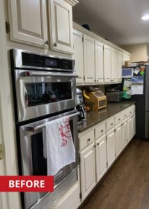 Wall oven built into white kitchen cabinets.
