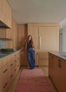 Neil Kelly design consultant, Tawni Peterson standing in a Portland kitchen condo.