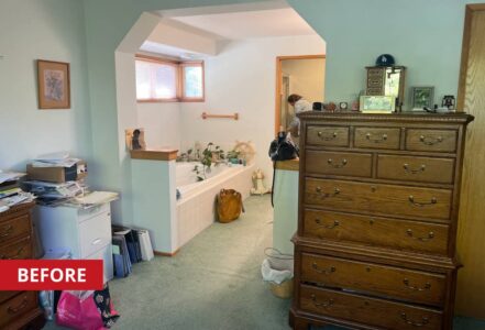 Cozy vintage bath area with a separate tub alcove, teal walls, and a wooden dresser.