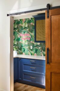 a walk-in pantry with botanical wallpaper