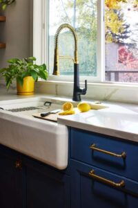 a kitchen sink and faucet with mixed metals