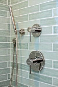 A close up of a bathtub valve and shower head