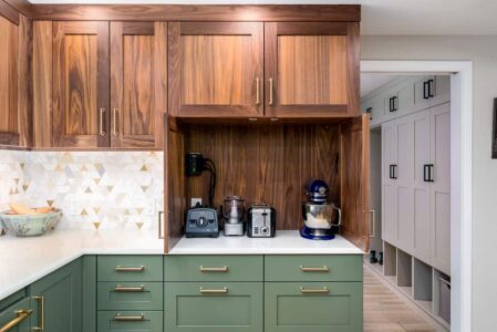 A remodeled kitchen with green and walnut cabinets