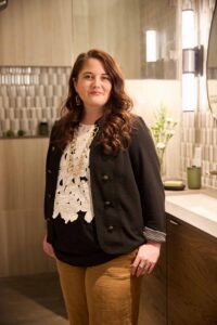 Interior Designer Jonne Vandehey standing in a remodeled primary bathroom